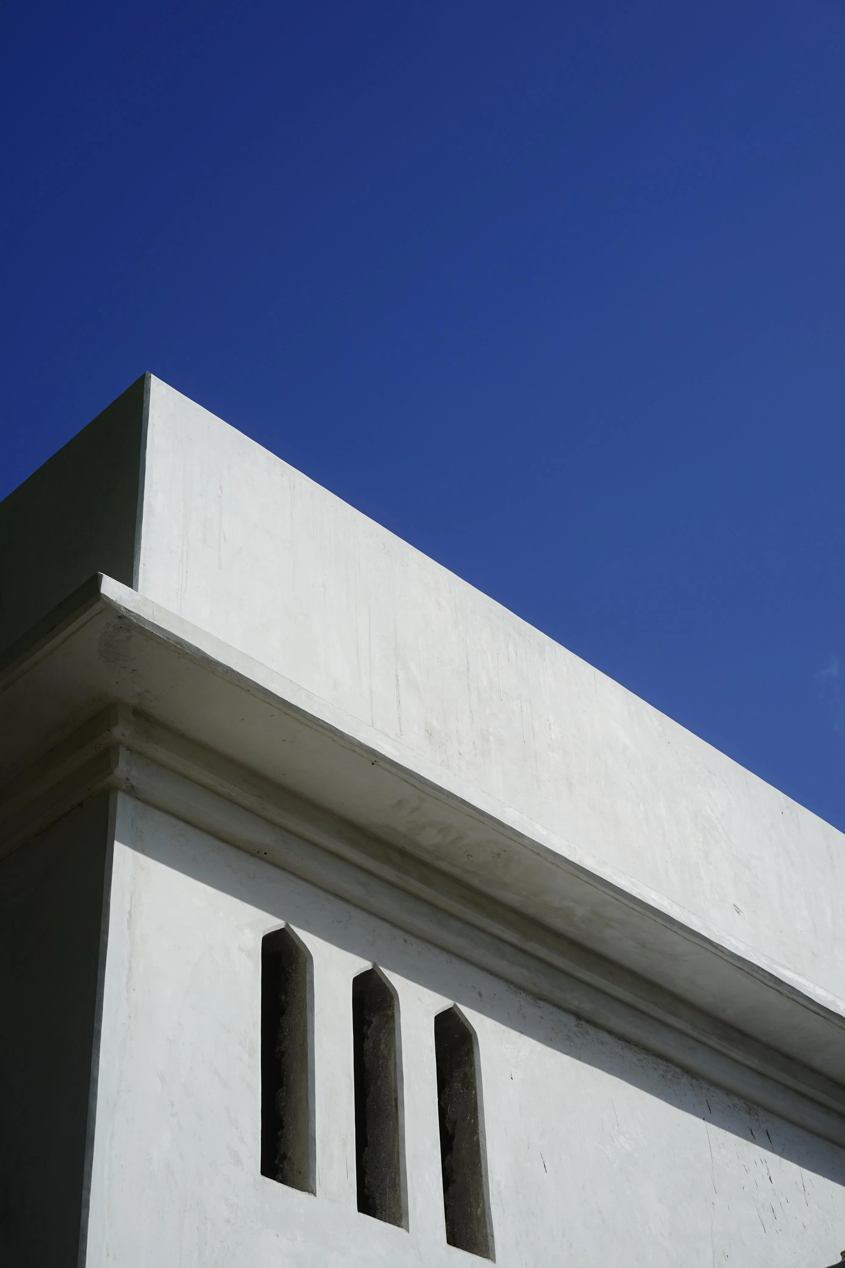 White rendered facade against cerulean sky